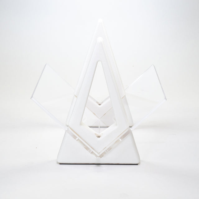 a white sculpture with a triangle on top of it