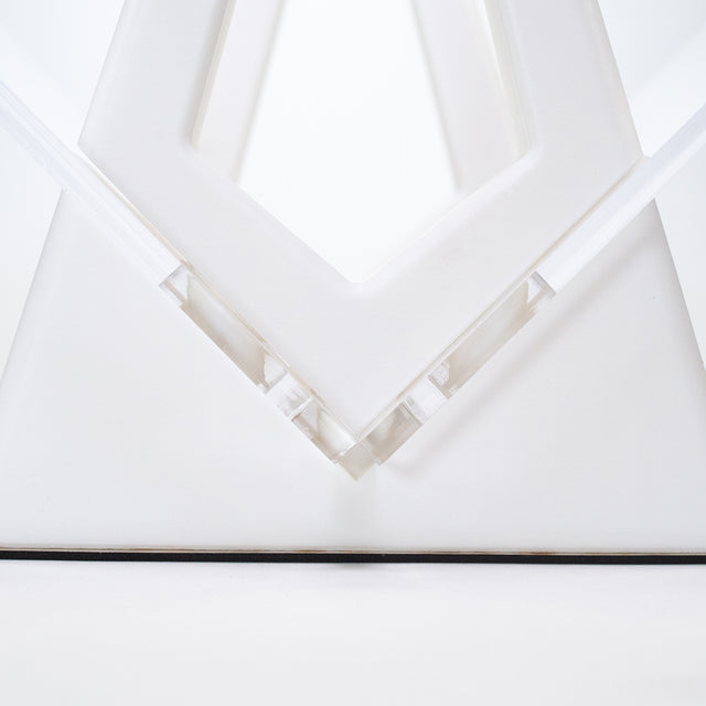 a white sculpture with a triangle shaped object in the middle of it