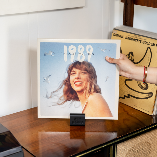 a woman holding up a picture of herself on a table