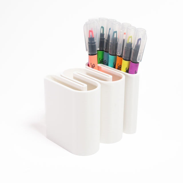 a group of pens and markers in a holder